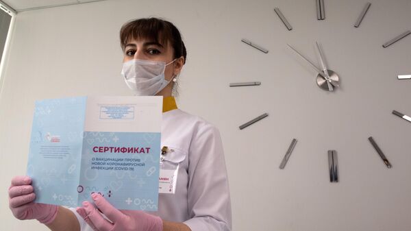 Медработник демонстрирует Сертификат о вакцинации от новой коронавирусной инфекции COVID-19