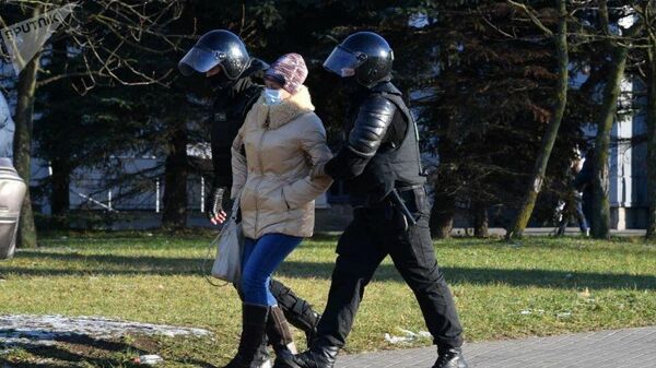 Сотрудники правоохранительных органов задерживают участницу несанкционированной акции протеста в Минске