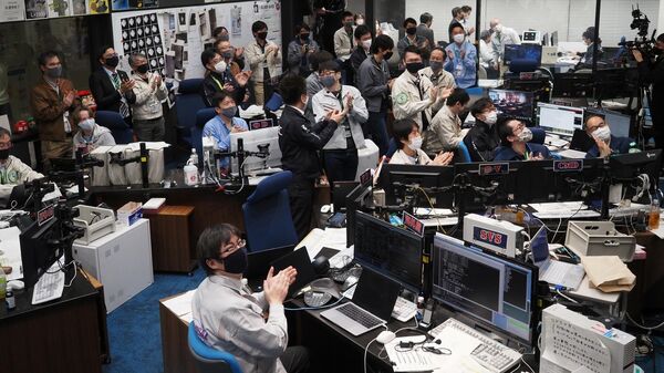 Участники проекта Хаябуса-2 наблюдают за прямой трансляцией возвращающейния капсулы в Сагамихаре, префектура Канагава
