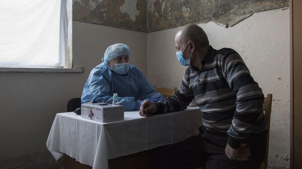 Врач выездной бригады медицинского отряда Минобороны РФ проводит прием пациента в селе Айгестан Аскеранского района Нагорного Карабаха