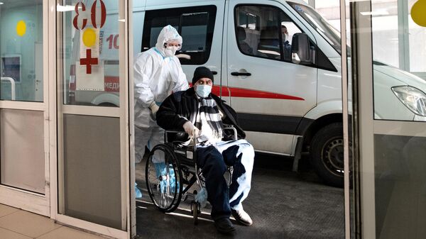 Сотрудник скорой медицинской помощи доставляет пациента в приемное отделение