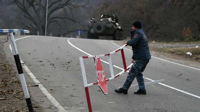 Полицейский возле контрольно-пропускного пункта на автомобильной дороге Варденис-Мартуни