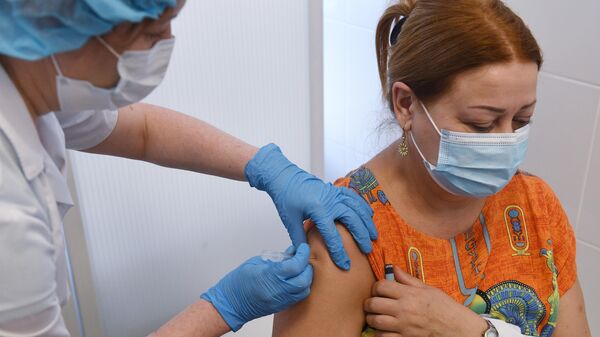 Медицинская сестра вводит вакцину Гам-КОВИД-Вак медработнику в прививочном кабинете городской клинической поликлиники №2 в Новосибирске