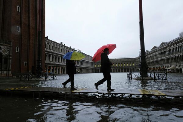 Люди на затопленной площади Святого Марка в Венеции