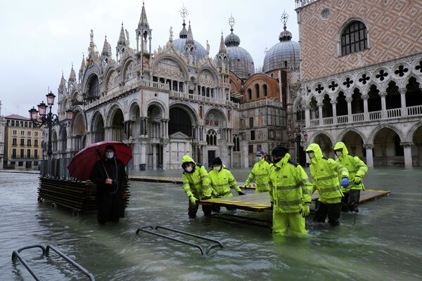 Рабочие на затопленной площади Святого Марка в Венеции