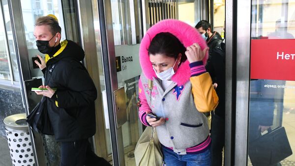 Люди в защитных масках выходят с одной из станций Московского метрополитена
