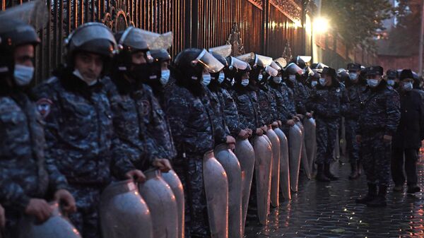 Сотрудники полиции следят за соблюдением порядка во время акции протеста около здания парламента Армении