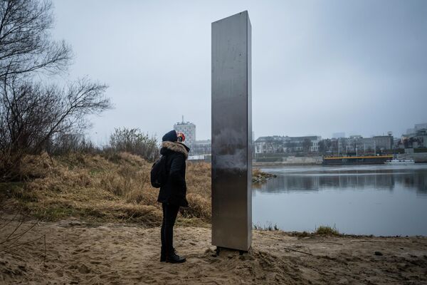 Девушка у металлической  стеллы на берегу Вислы в Варшаве 