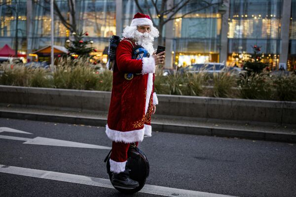 Мужчина в костюме Санта-Клауса едет по бульвару Курфюрстендамм в Берлине