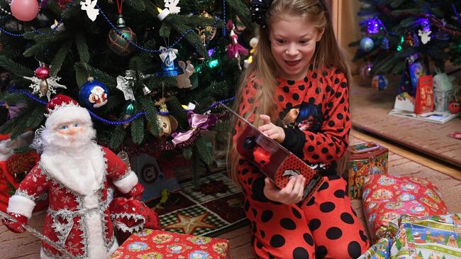 Девочка Маша получает подарки во время празднования Нового года в Москве
