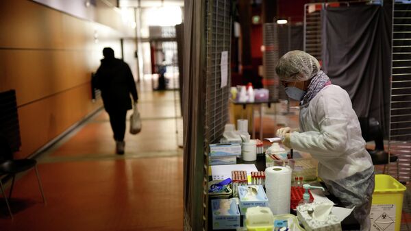 Медицинский работник в защитном костюме в центре тестирования на коронавирус во Франции