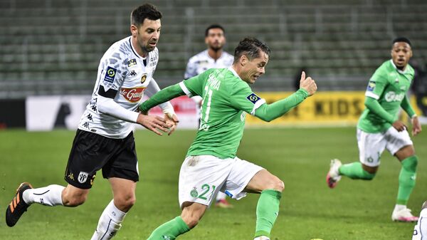 Saint-Etienne's French forward Romain Hamouma (R) fights for the ball with Angers' French midfielder Thomas Mangani (L) during the French L1 football match between AS Saint-Etienne and SCO Angers at the Geoffroy Guichard stadium in Saint-Etienne, central France, on December 11, 2020. (Photo by PHILIPPE DESMAZES / AFP)