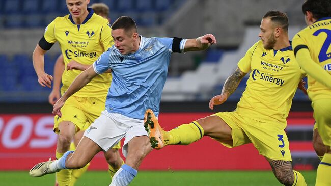 Lazio's Serbian defender Adam Marusic (L) shots over Verona's Italian defender Federico Dimarco during the Italian Serie A football match between Lazio and Verona at the Olympic stadium in Rome, on December 12, 2020. (Photo by Vincenzo PINTO / AFP)