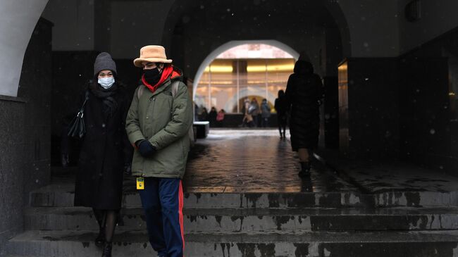 Прохожие в защитных масках на одной из улиц в Москве