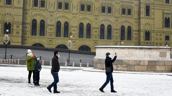 Прохожие в защитных масках на Красной площади в Москве