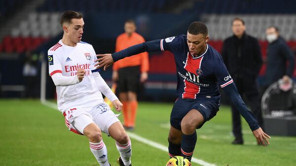 Lyon's French midfielder Maxence Caqueret (L) vies with Paris Saint-Germain's French forward Kylian Mbappe (R) during the French L1 football match between Paris Saint-Germain (PSG) and Lyon (OL), on December 13, 2020 at the Parc des Princes stadium in Paris. (Photo by FRANCK FIFE / AFP)