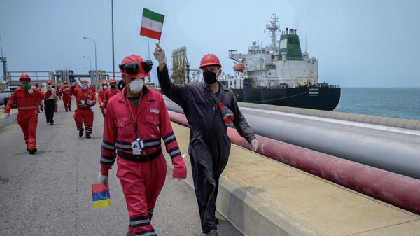 Сотрудники нефтяных компаний с флагами Венесуэлы и Ирана в порту Венесуэлы
