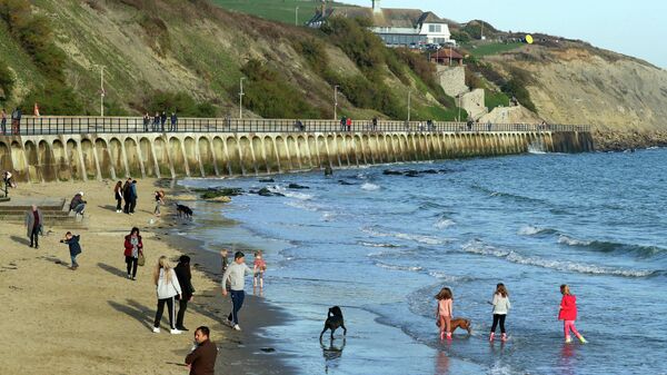 Люди гуляют на пляже в графстве Кент в Великобритании