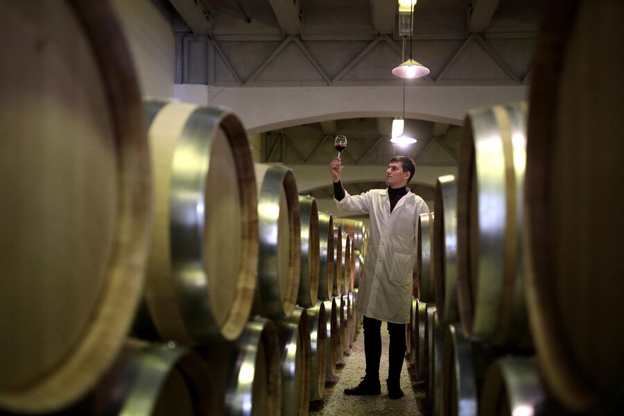 Винодел в отделении выдержки на заводе Кубань-Вино в станице Старотитаровская в Темрюкском районе Краснодарского края