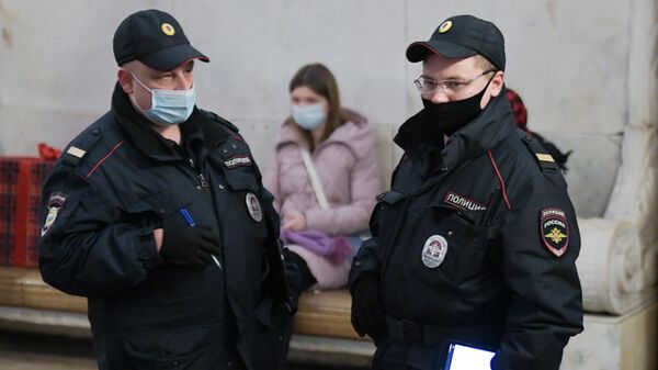 Представители правоохранительных органов в защитных масках на станции в московском метрополитене