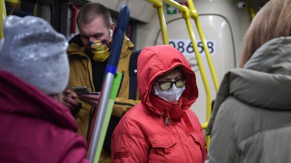 Пассажиры в защитных масках в вагоне электропоезда московского метрополитена
