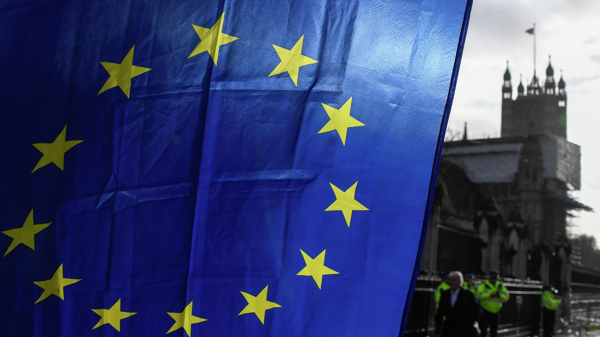 Флаг ЕС в руках демонстранта на фоне башни Виктория у Вестминстерского дворца в Лондоне. 14 декабря 2020 - РИА Новости, 1920, 30.01.2021