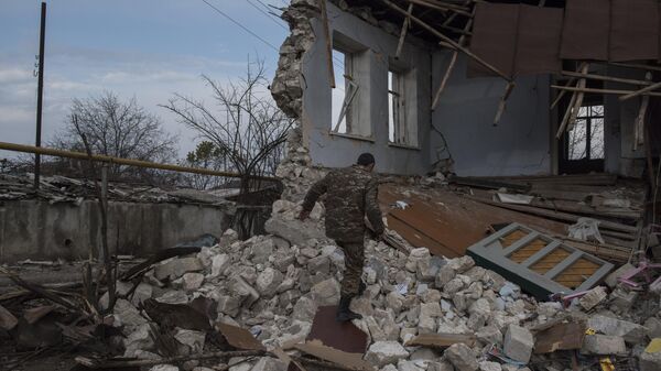 Мужчина возле разрушенного дома в городе Мартакерт в Нагорном Карабахе