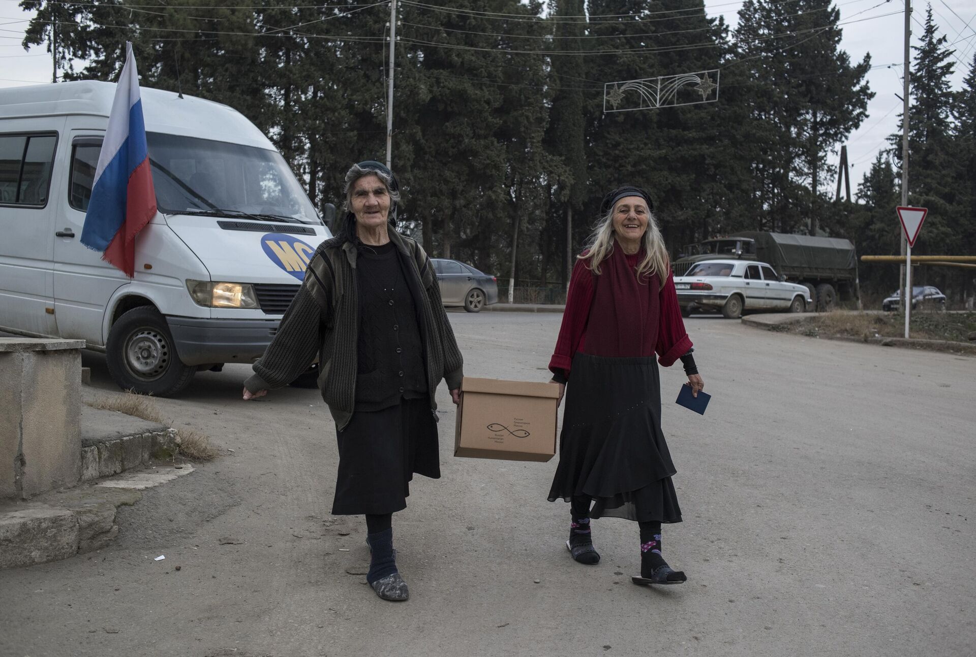 Местные жители несут домой коробку с гуманитарной помощью в городе Мартакерт в Нагорном Карабахе - РИА Новости, 1920, 16.12.2020