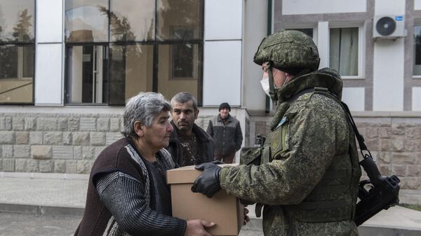 Военнослужащий российского Центра по примирению враждующих сторон раздает гуманитарную помощь жителям города Мартакерт . Архивное фото