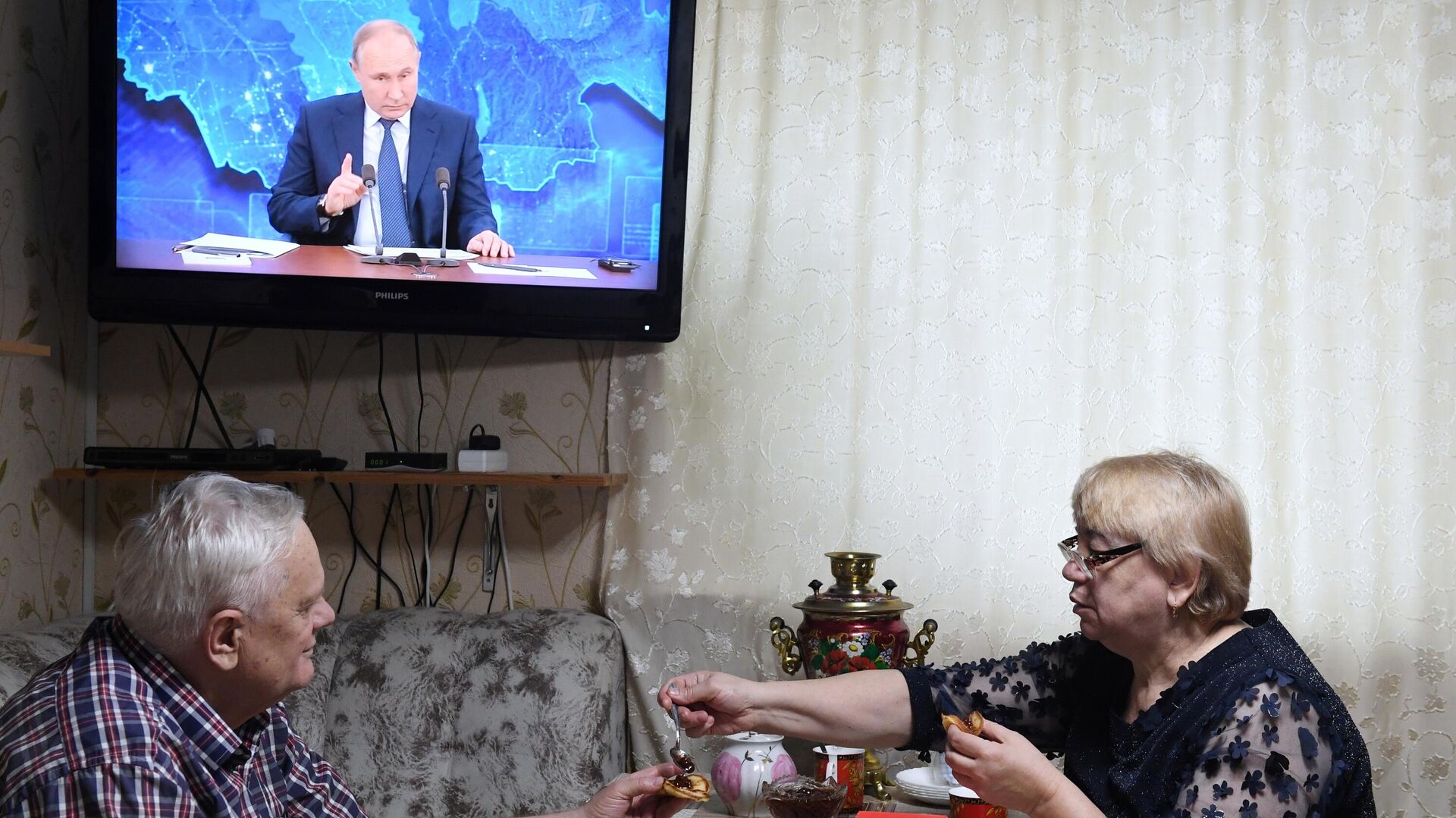 Пенсионеры пьют чай и смотрят прямую трансляцию ежегодной большой пресс-конференции президента РФ Владимира Путина в Казани Пенсионеры пьют чай и смотрят прямую трансляцию ежегодной большой пресс-конференции президента РФ Владимира Путина в Казани - РИА Новости, 1920, 23.12.2020