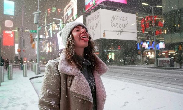 Девушка ловит снежинки во время снегопада в Нью-Йорке 