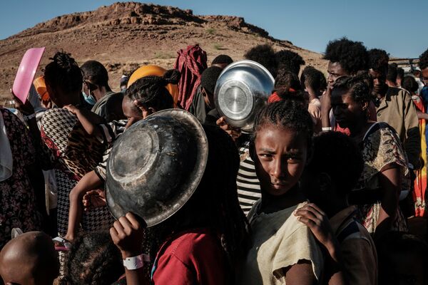 Эфиопские дети стоят в очереди за едой в лагере для беженцев Ум-Ракуба в Судане