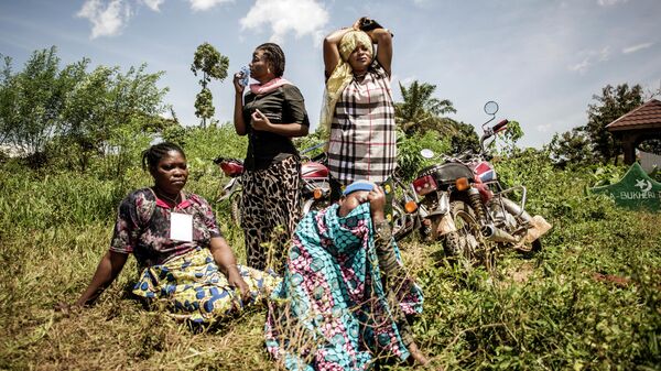 Женщины оплакивают кончину члена семьи во время похорон на окраине города Бени, провинция Северное Киву