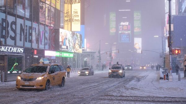 Движение автомобилей во время снегопада на Таймс-сквер в Нью-Йорке