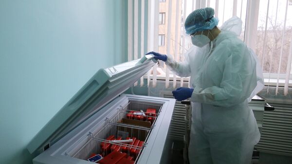 Медсестра достает из холодильника упаковку с вакциной от коронавируса Гам-Ковид-Вак 