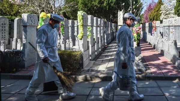 Рабочие моют надгробные камни на кладбище в Китае 