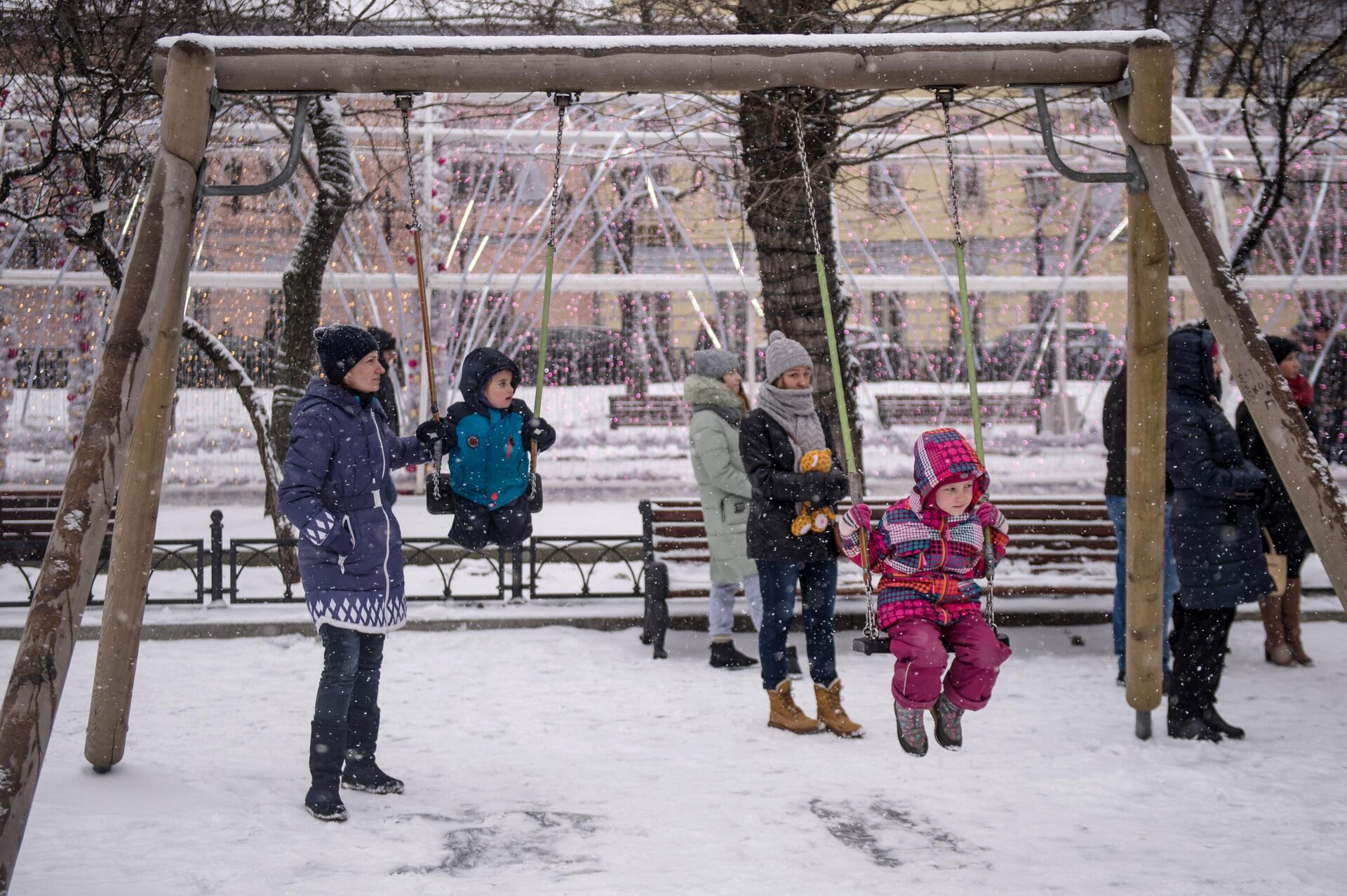 Дети с родителями качаются на качелях на Тверском бульваре в Москве Дети с родителями качаются на качелях на Тверском бульваре в Москве - РИА Новости, 1920, 23.12.2022
