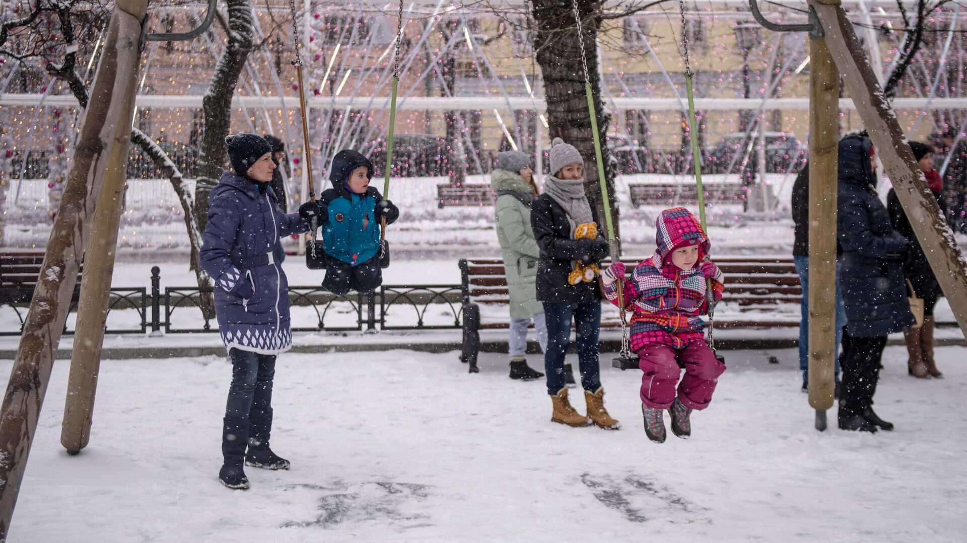 Дети с родителями качаются на качелях на Тверском бульваре в Москве - РИА Новости, 1920, 10.01.2021