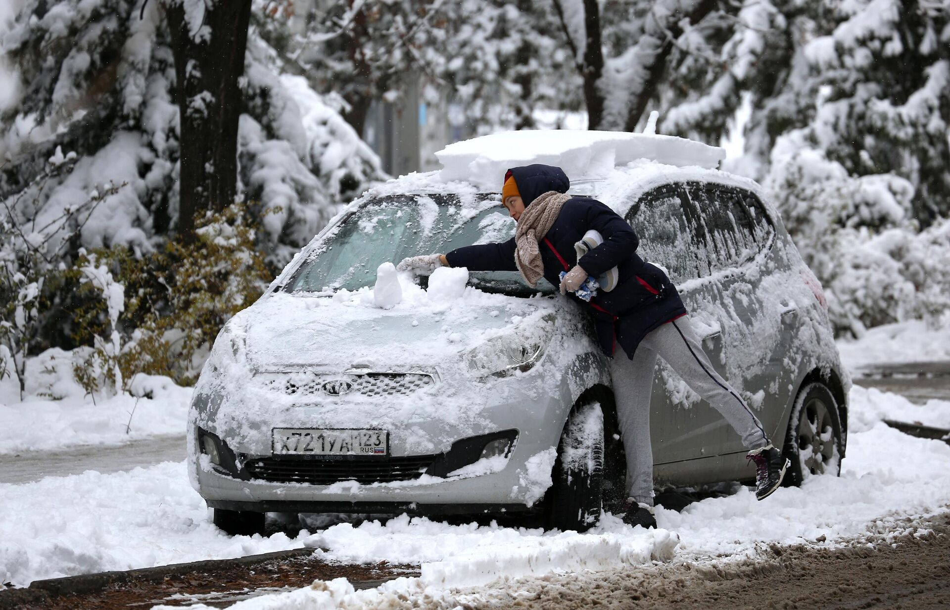 Женщина очищает свой автомобиль от снега - РИА Новости, 1920, 19.01.2022
