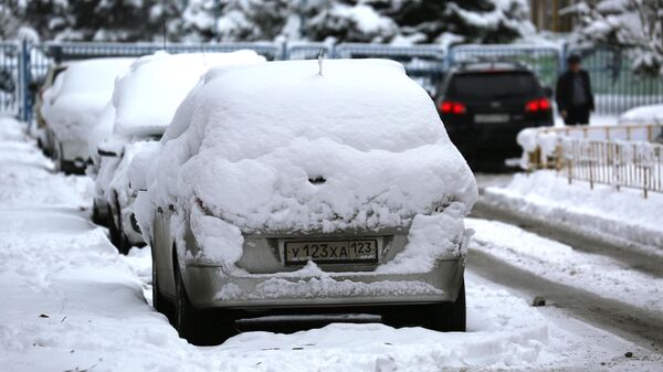 Заснеженные машины в одном из дворов в Краснодаре после снегопада