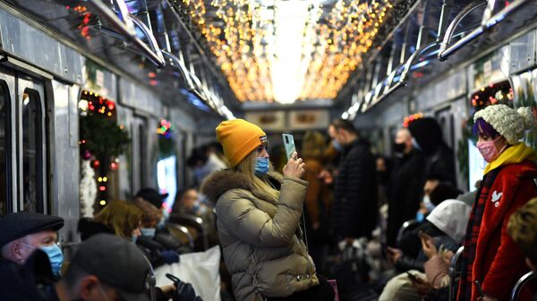 Пассажиры в вагоне новогоднего поезда серии Ёж Московского метрополитена