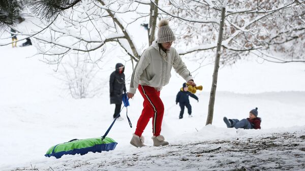 Люди катаются со снежной горки в Краснодаре после снегопада
