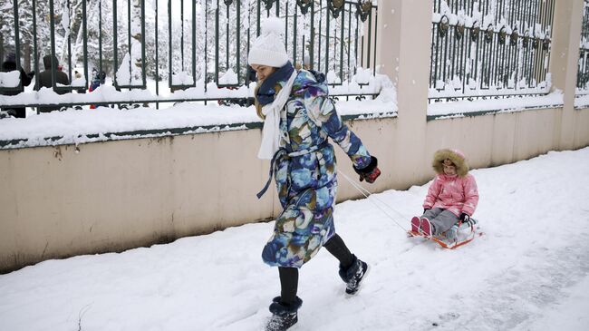 Женщина с ребенком на улице Красных Партизан в Краснодаре после снегопада