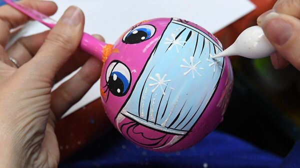 Художница расписывает стеклянный новогодний шар на фабрике игрушек Бирюсинка в Красноярске