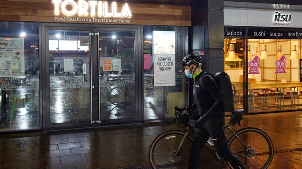 Велосипедист в медицинской маске на одной из опустевших улиц Лондона