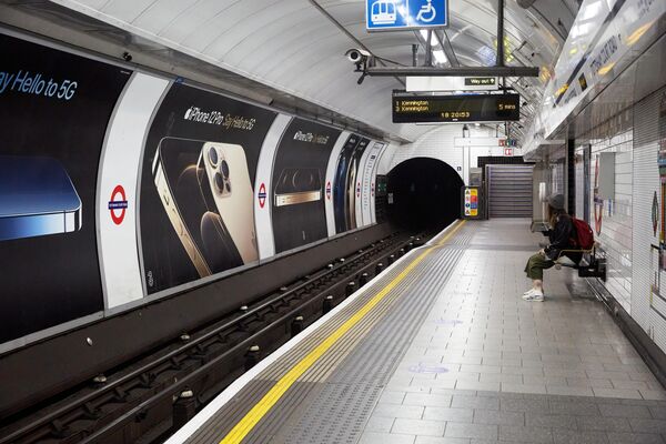 Девушка ждет поезд на перроне лондонского метро