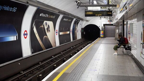 Девушка ждет поезд на перроне лондонского метро
