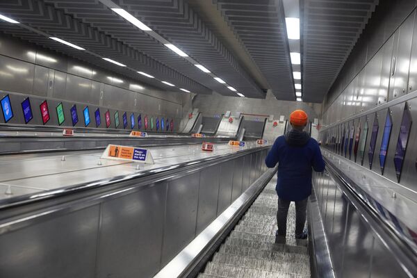 Молодой человек на эскалаторе лондонского метро