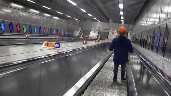 Молодой человек на эскалаторе лондонского метро