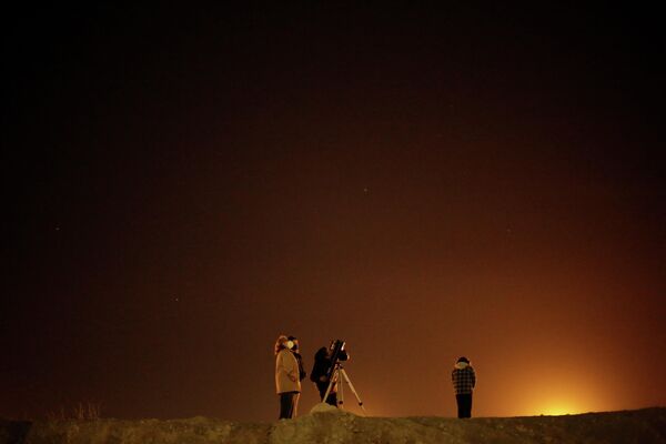 Люди наблюдают в телескоп за встречей Юпитера и Сатурна в Сьюдад-Хуарес, Мексика